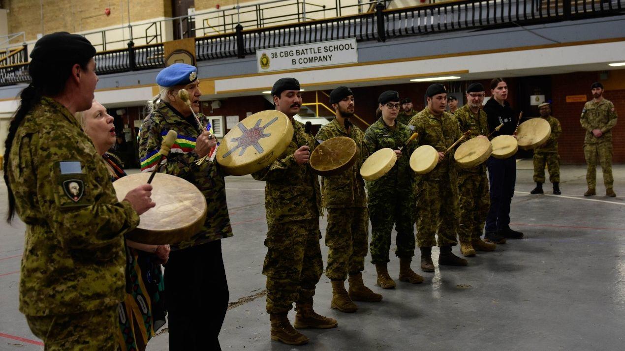 Military personnel participating in drumming.