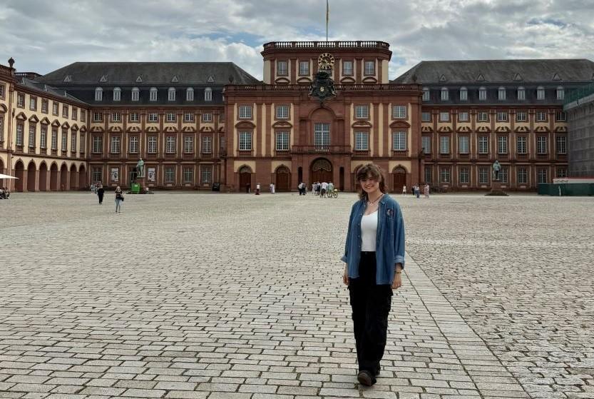 Maya debout devant un bâtiment en Allemagne.