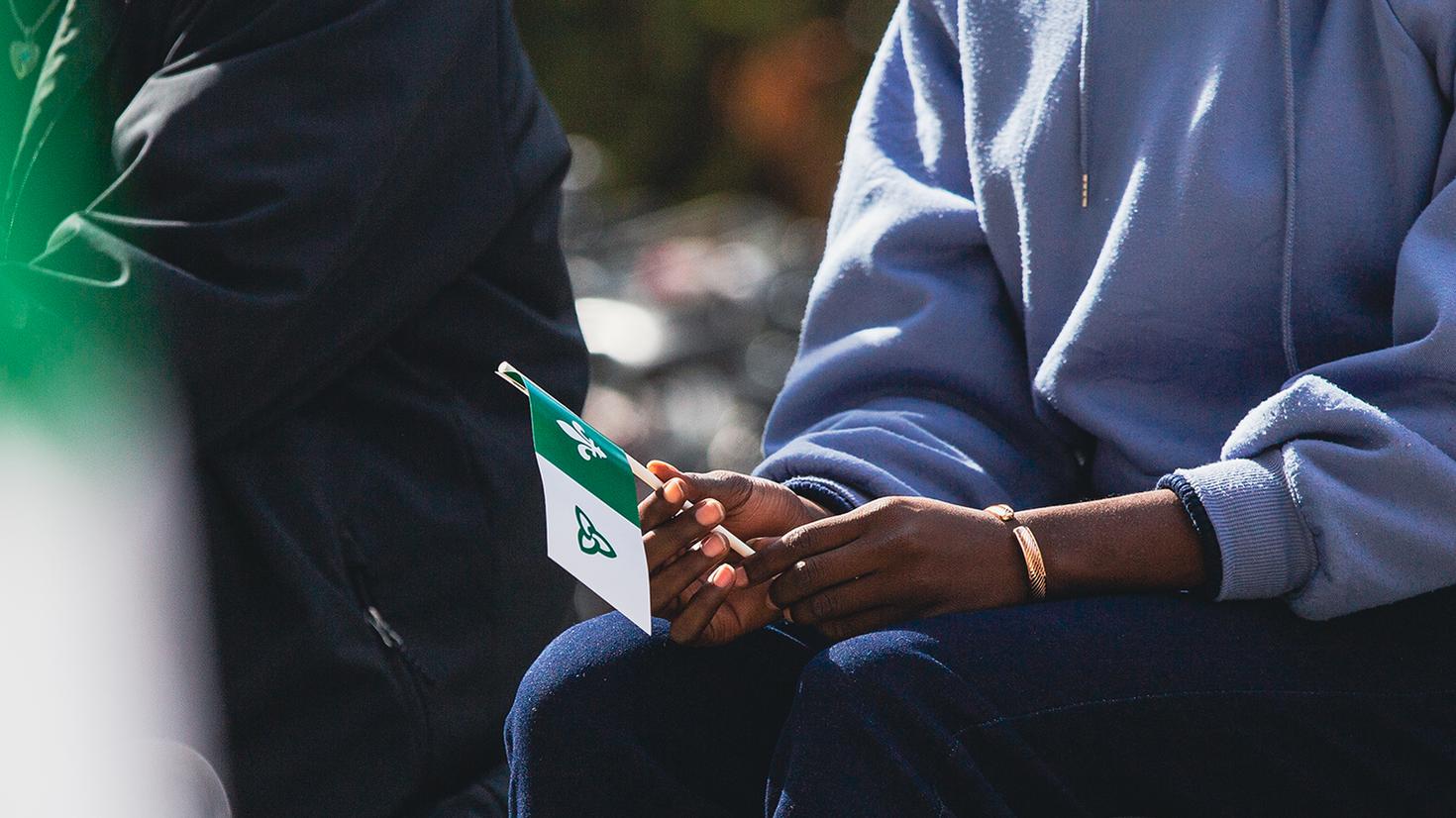 une main tenant un drapeau Franco-ontarien
