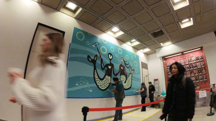 Une fresque murale représentant deux êtres animés sous l'eau.