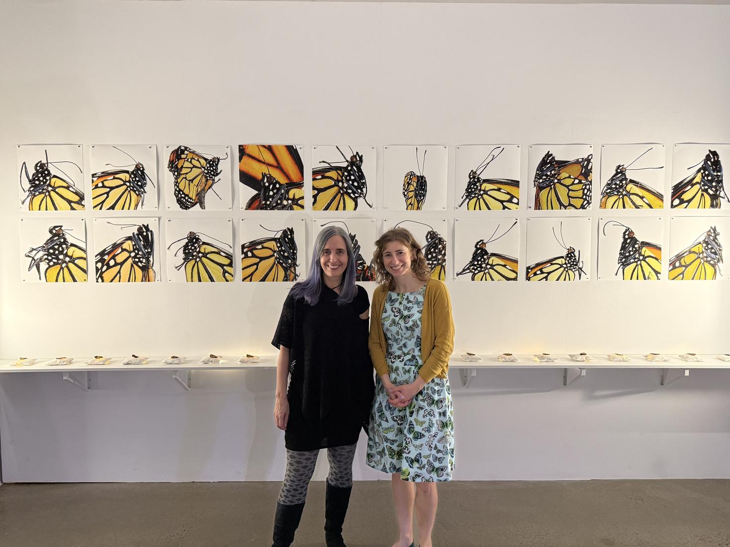 Valérie Chartrand and Heather Kharouba standing in front of the "Flutterings" exhibit.