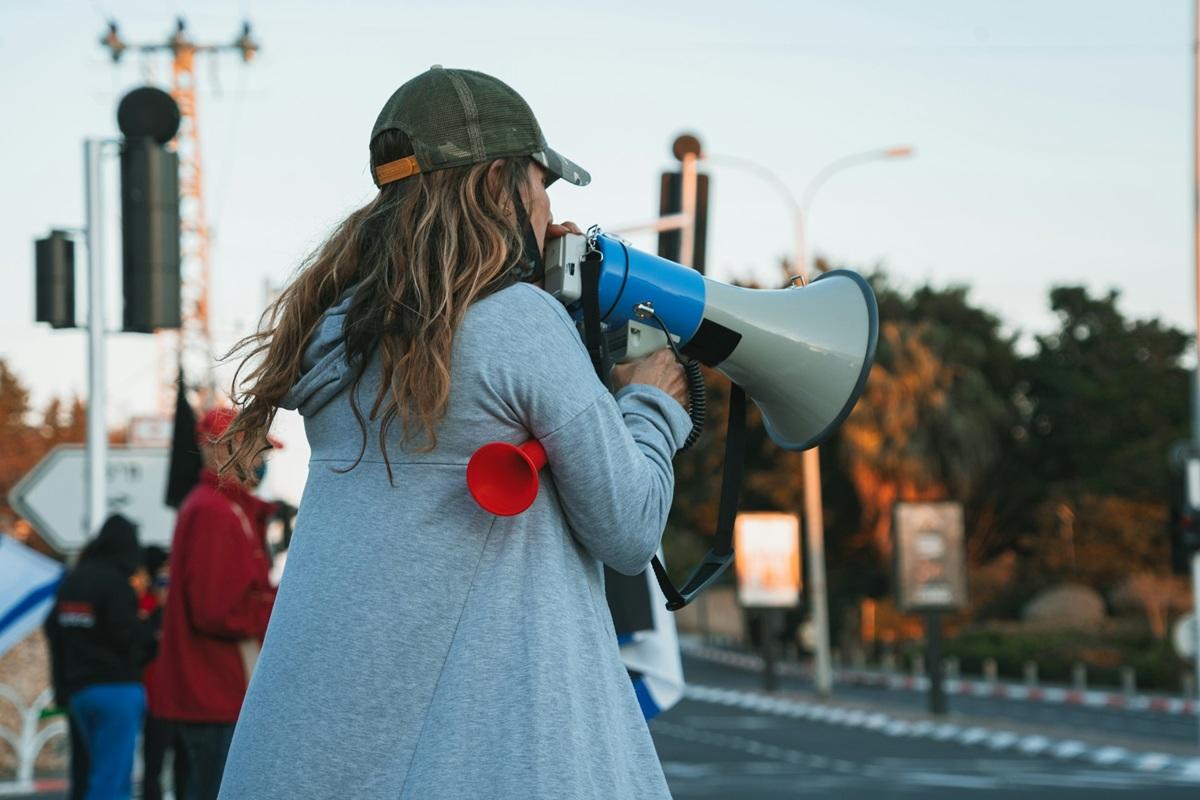 Woman leading strike chant with megaphone