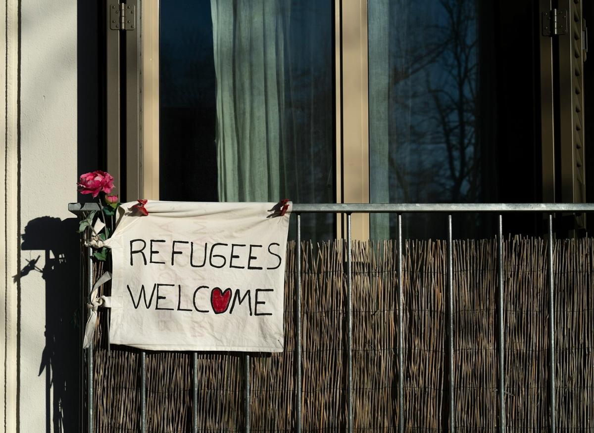 Refugees Welcome sign hanging from a balcony