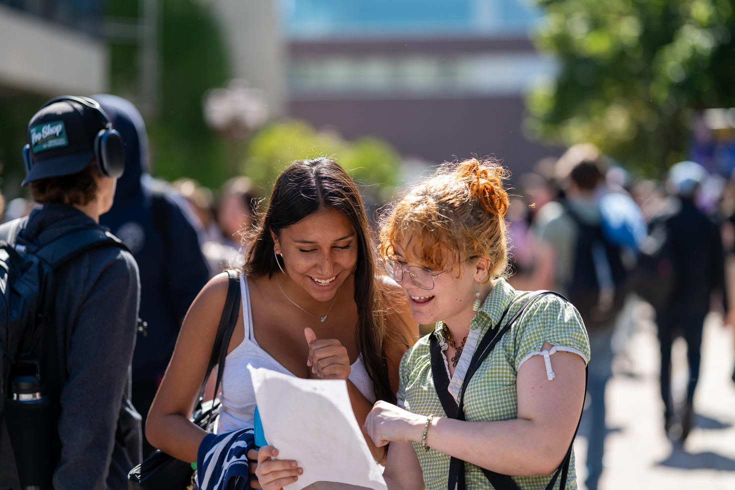 Two students looking at a sheet of paper on the Grande Allée.