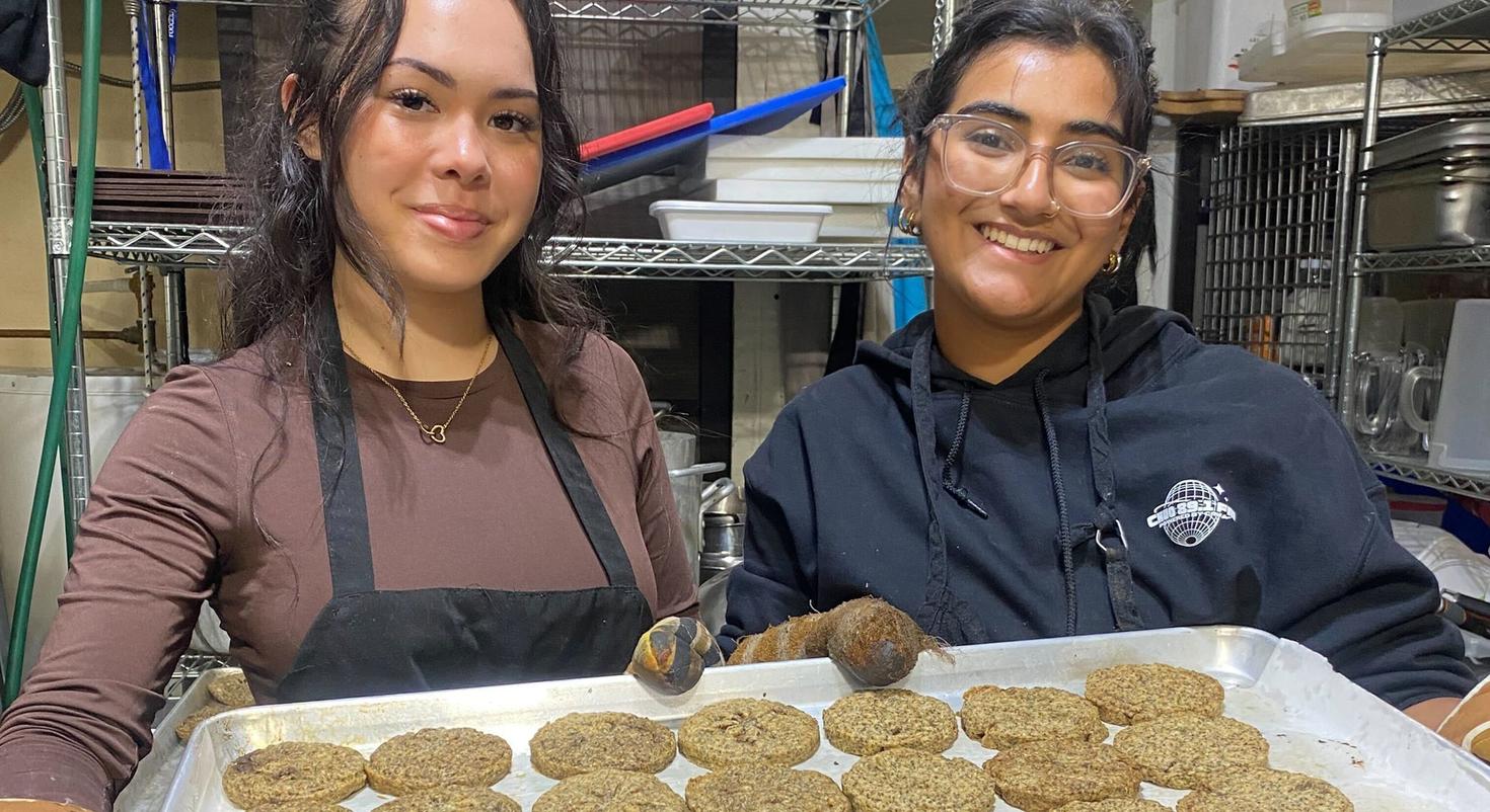 Deux étudiantes présentent un plateau de biscuits.