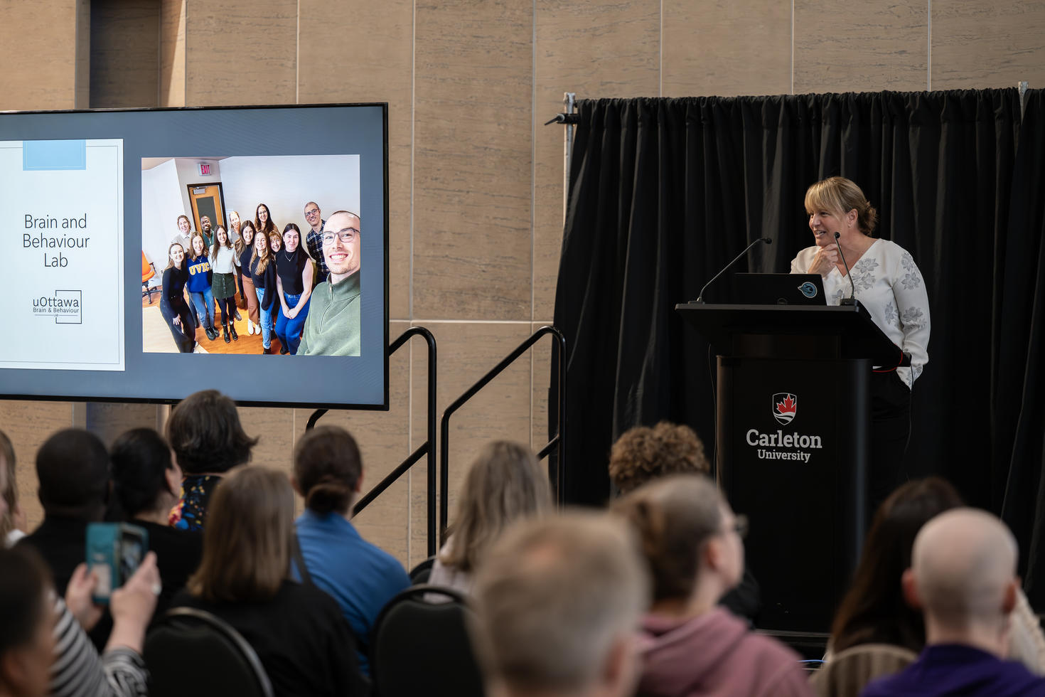 Tracy Vaillancourt speaking from a podium.