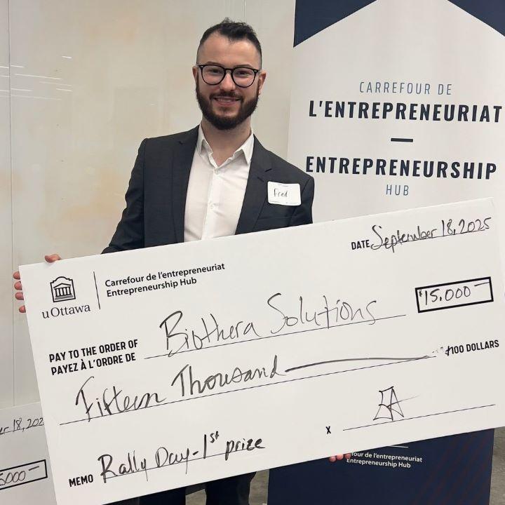 Frédéric St-Denis-Bissonnette, CEO of BioThera, holds a giant cheque.