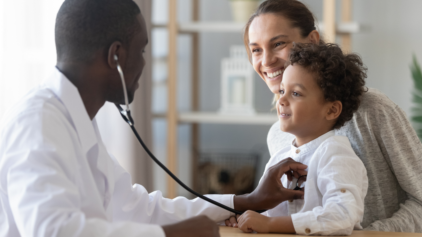 A doctor in a health clinic using a stethoscope to listen to a child's heartbeat.