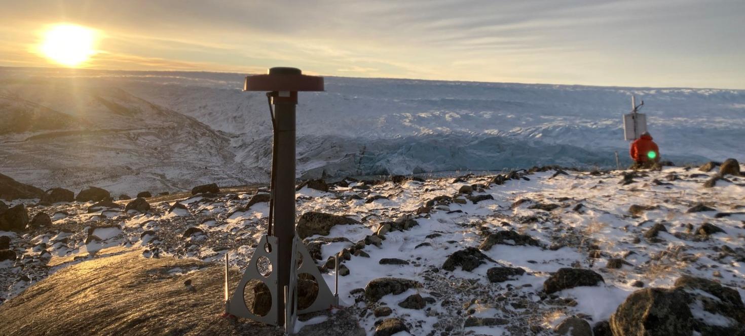 Sun rise at a Global Navigation Satellite System (GNSS) station near Kangerlussuaq in western Greeland. Dr. Ajourlou uses the 3D land motion recorded by these stations to learn about the history of the ice sheet and rheological properties of the underlying crust and mantle. Photo credit: Kristian K. Kjeldsen, Geological Survey of Denmark and Greenland.”