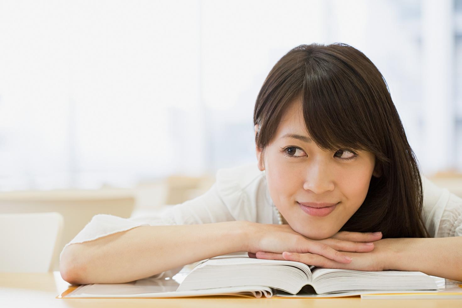 Student leaning on opened books