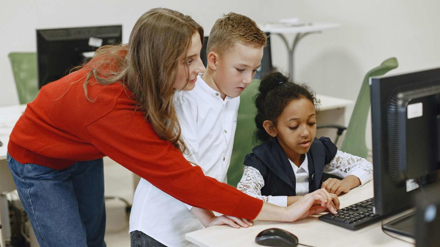 Jeune devant un ordinateur avec un enseignant.
