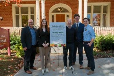 University and student union leaders pose in front of a Health Plates Summit sign outside the Alex Trebek Alumni Hall.