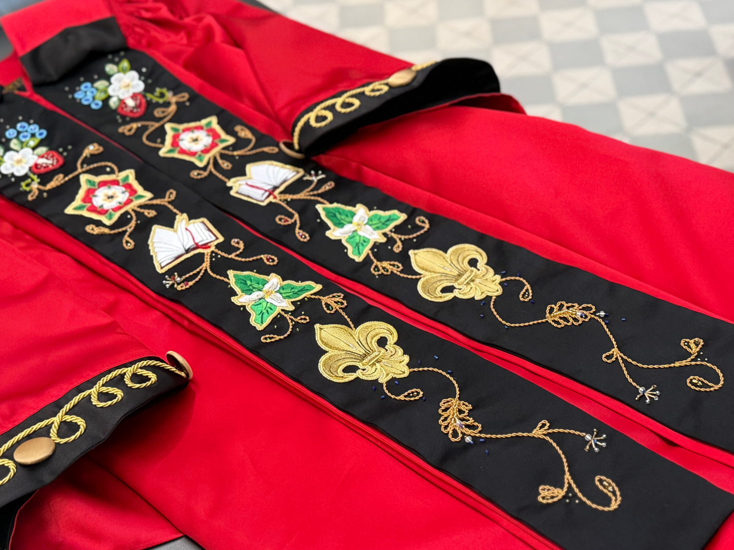 uOttawa presidential stole featuring beaded flowers, the Fleur-de-Lys, the Tudor Rose, the Trillium flower and an open book. 