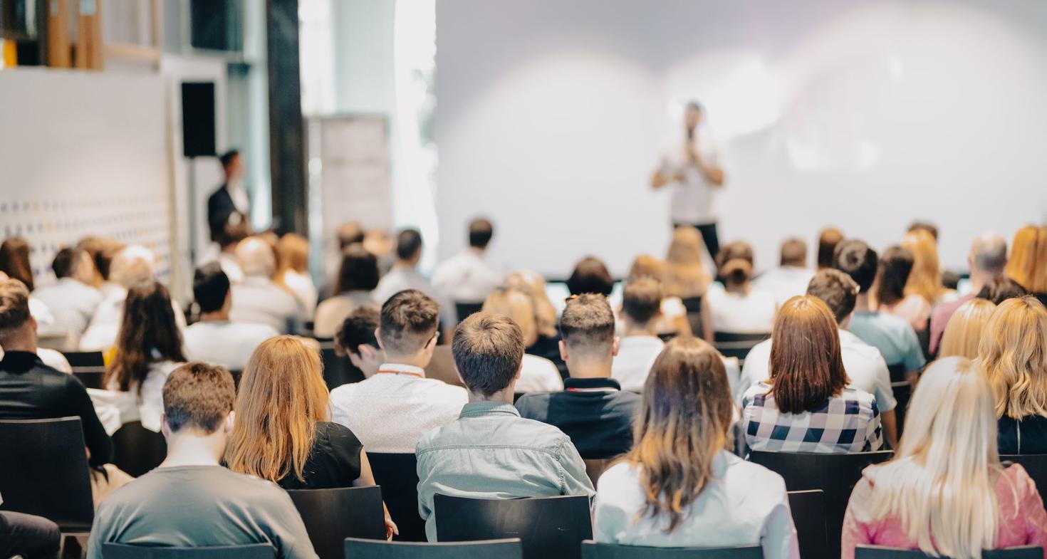 Speaker giving a talk in front of a seated crowd