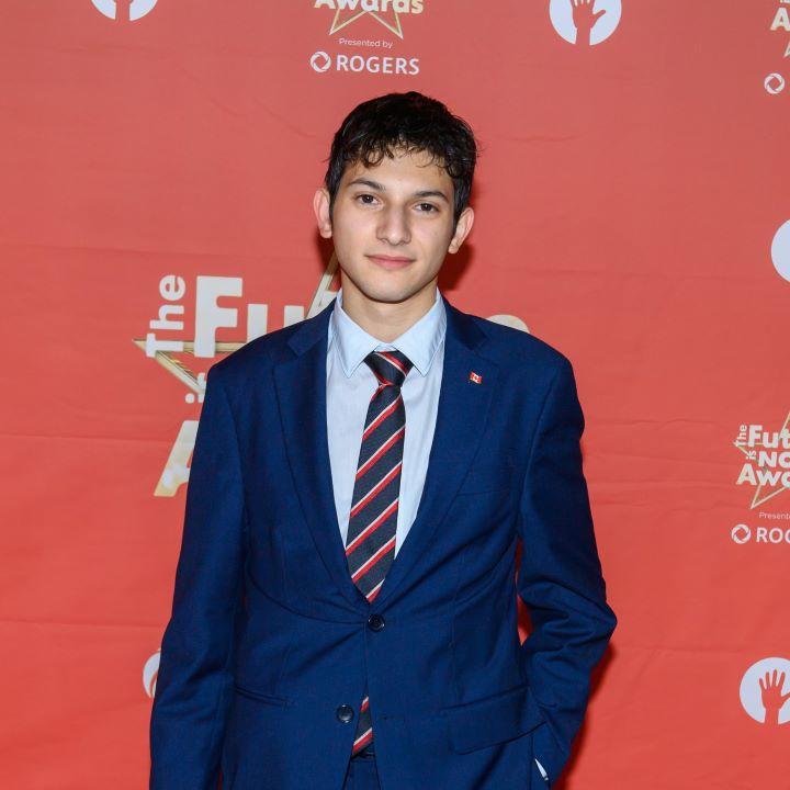 Santiago Proteau-Sanchez pose devant un fond rouge au prix "Le Futur, c'est Maintenant". 