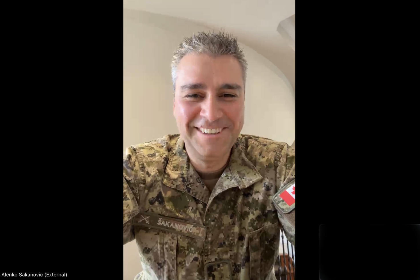 A person in a military uniform smiles for a photo.