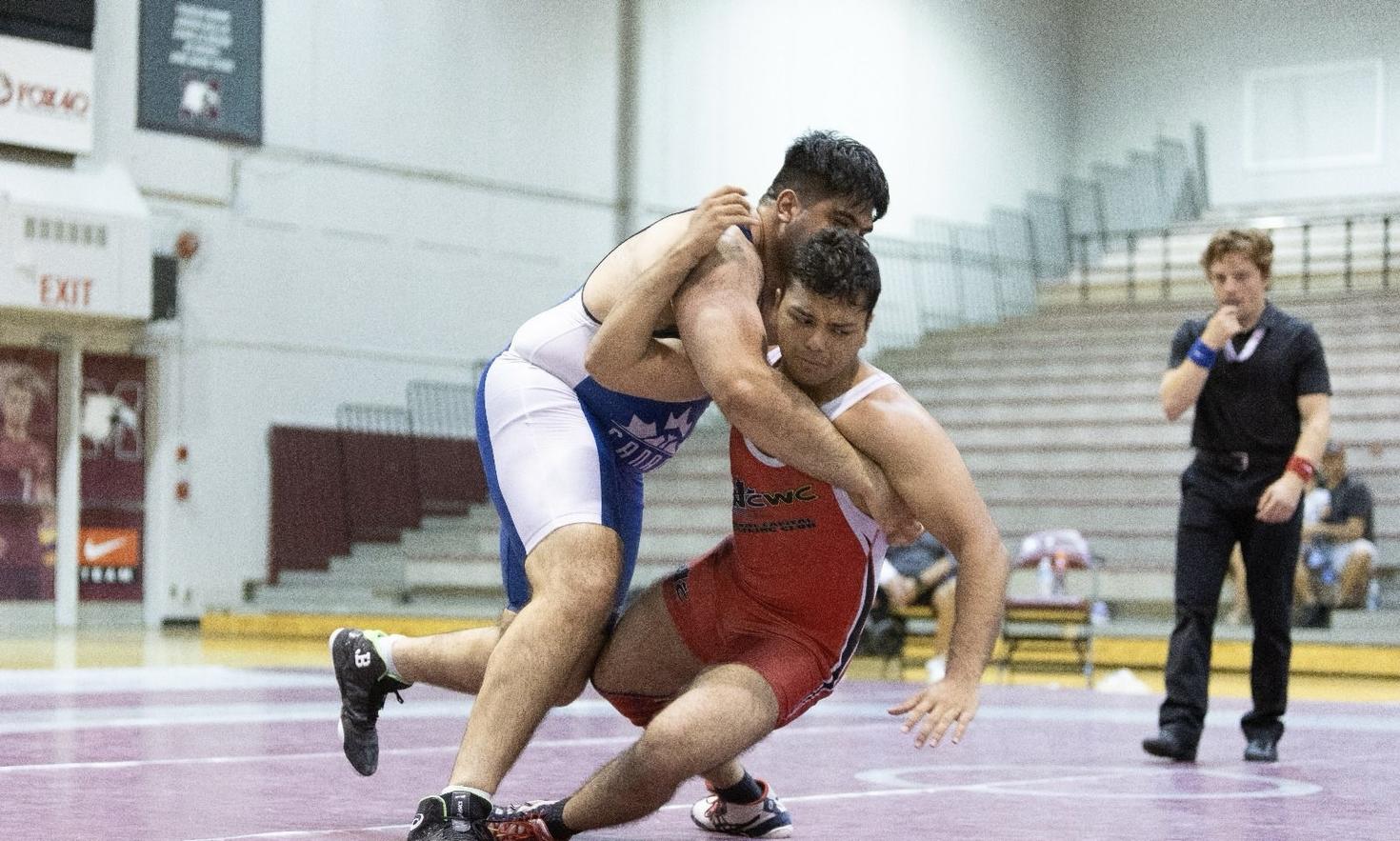 Moiz Lakhani grappling an opponent during a wrestling match.