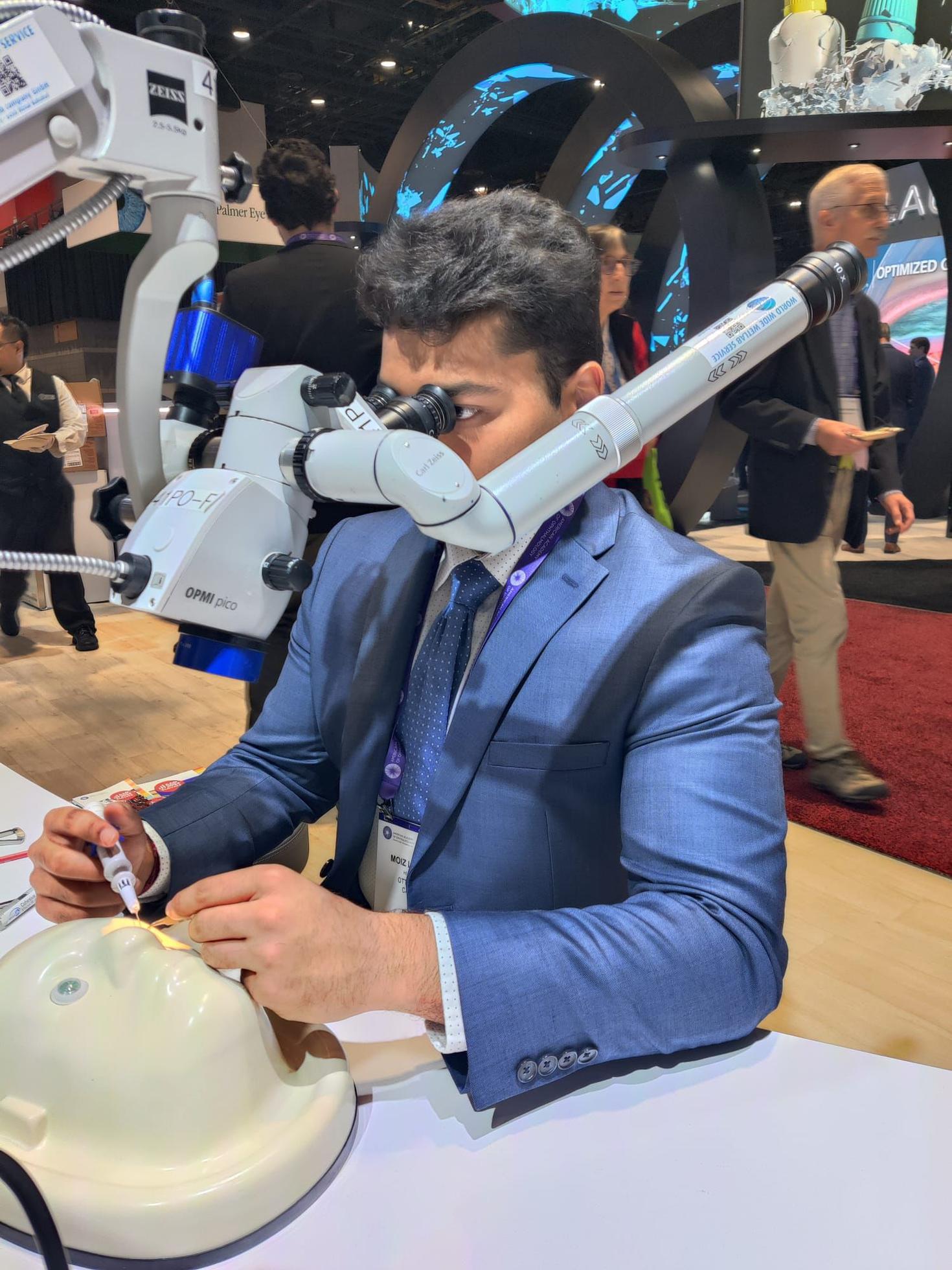 Moiz Lakhani utilisant un microscope chirurgical.