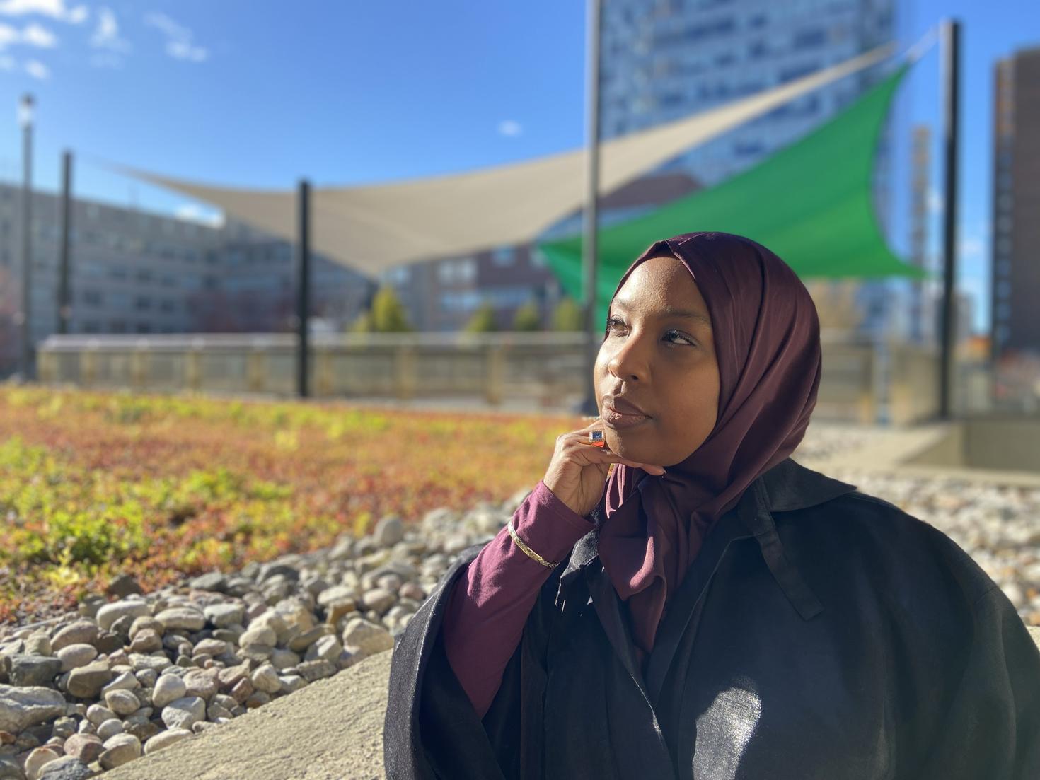 Awa Ndiaye, sur le campus universitaire, avec des pare-soleil blancs et verts en arrière-plan.