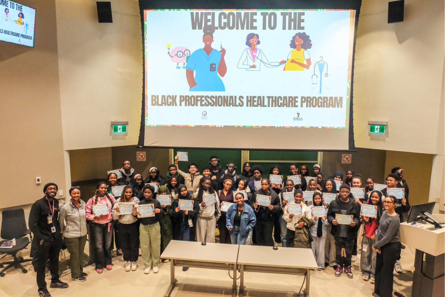 A group of high school students stand in a group holding participation certificates