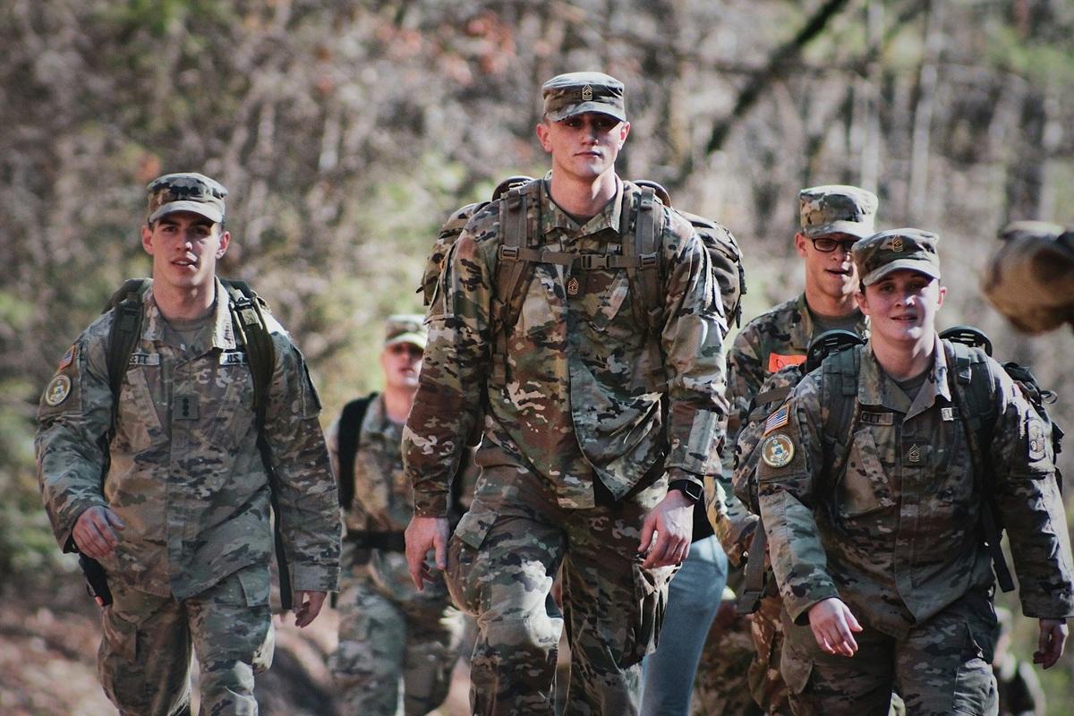 Men in camouflage in uniform standing on a field in daytime