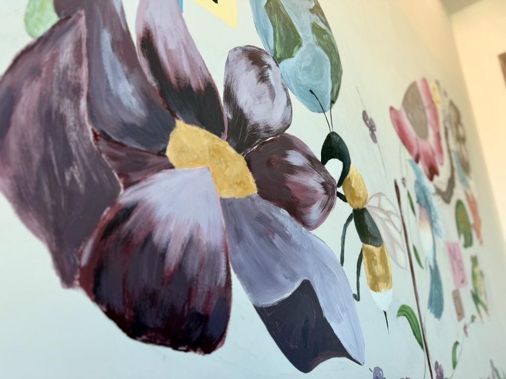 Close up on a mural painting of a flower with bee.