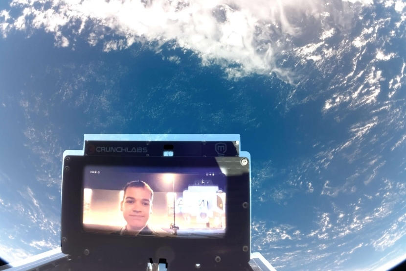 A screen in space displaying a photo of Maxime Couture.