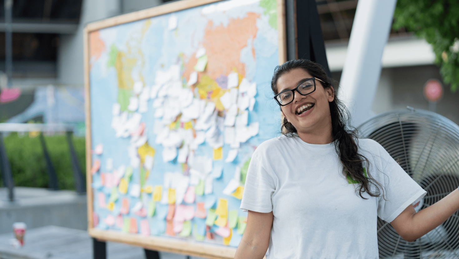 Smiling uOttawa student in front of map.