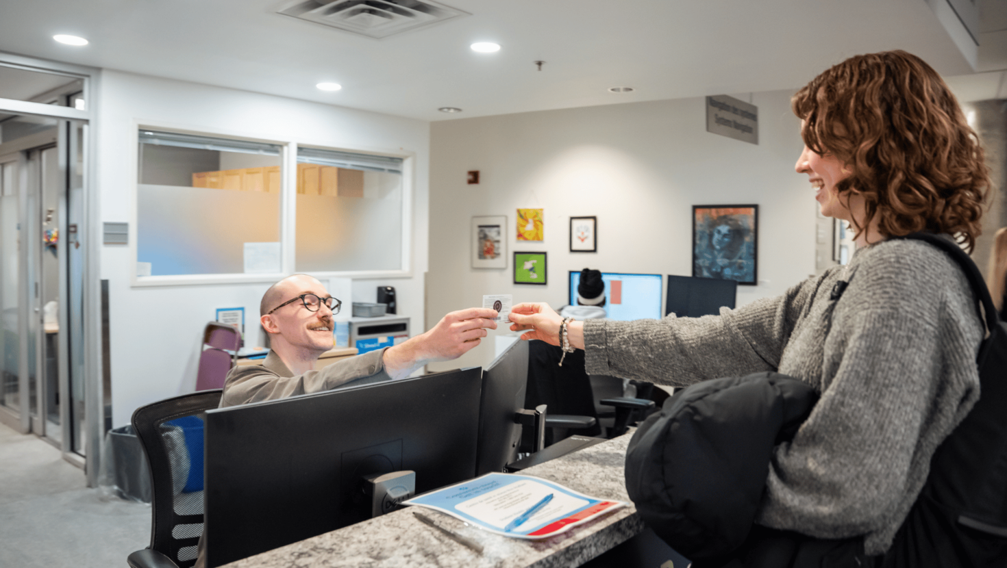 Student handing their student card to uOttawa staff.