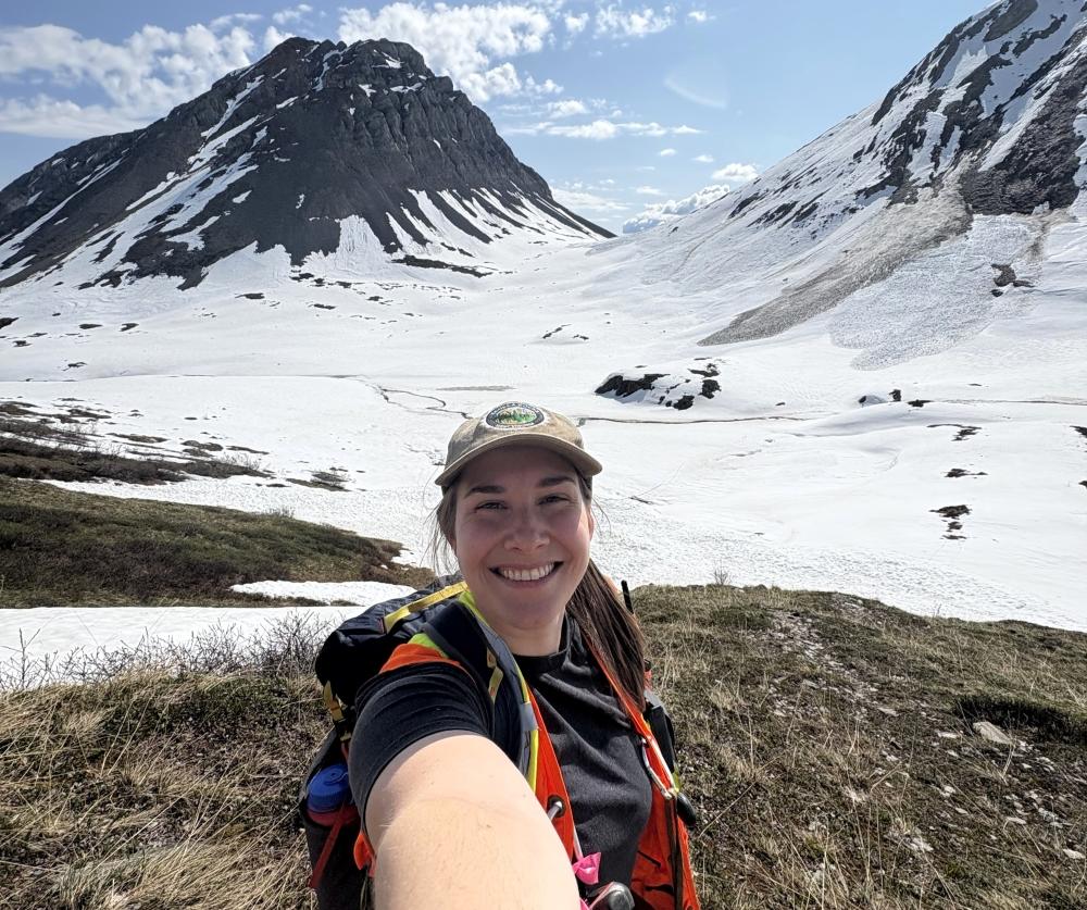 Laurence Hamel, tout sourire, pose devant des montagnes enneigées. 