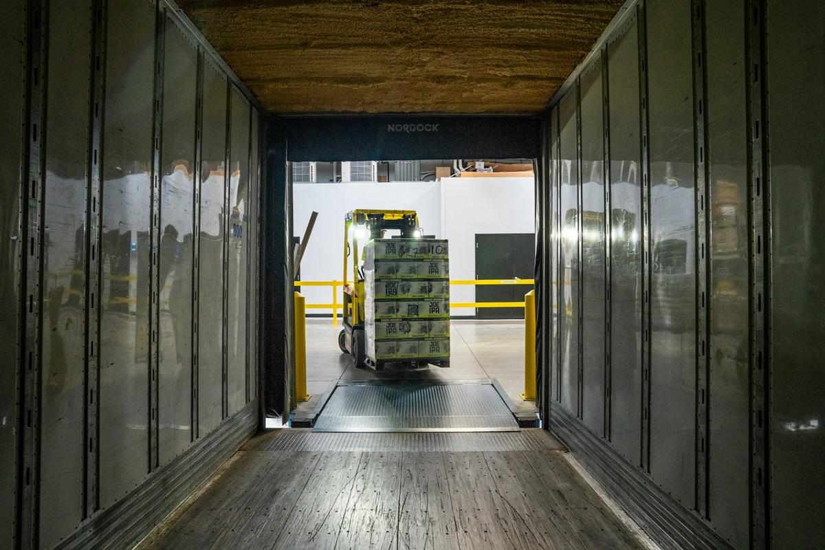 Chariot élévateur chargant des produits dans un conteneur d'expédition