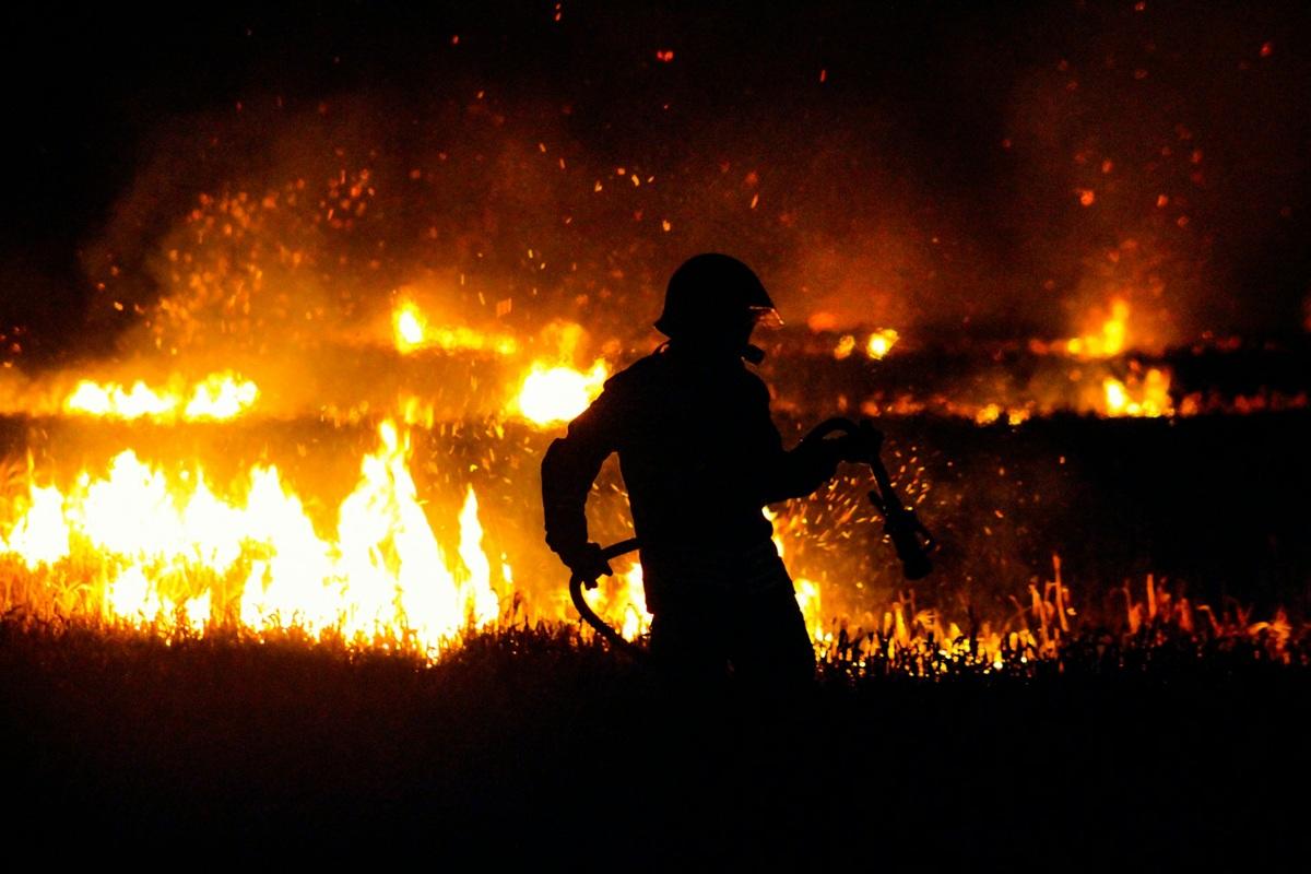 Firefighter fighting blaze at night