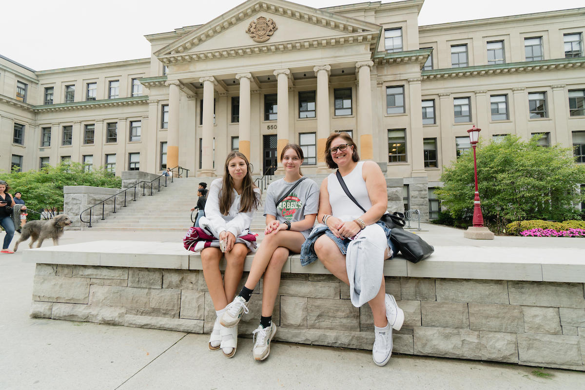 Family seated in front of Tabaret Hall.