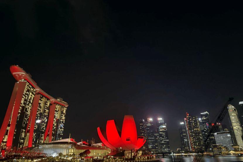 High rise buildings in Singapore lit up at night.