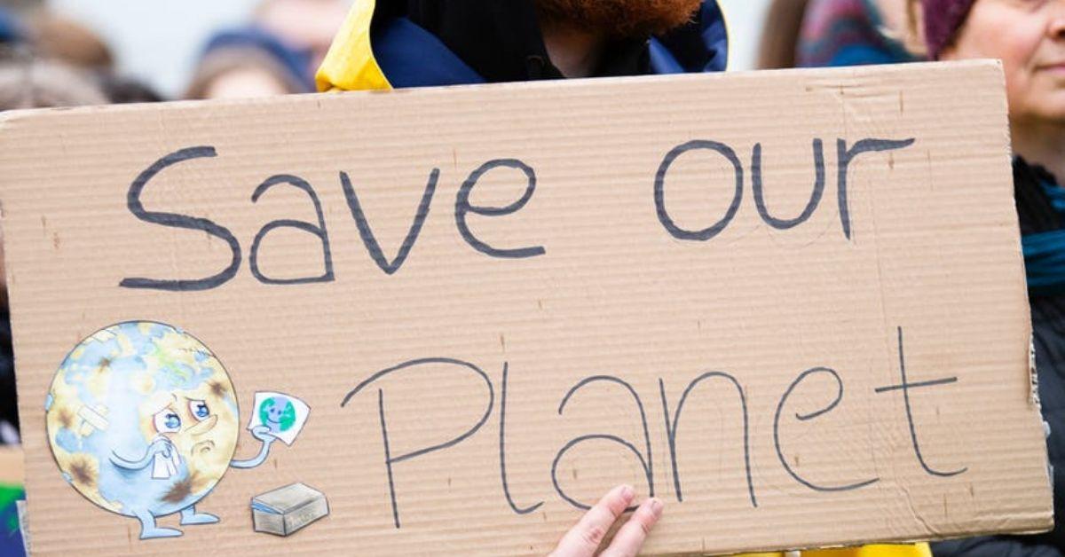 Une affiche en carton sur laquelle est écrit «Sauver la planète»