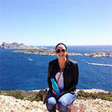 caitrd assise sur des rochres devant l'océan un jour ensoleillé