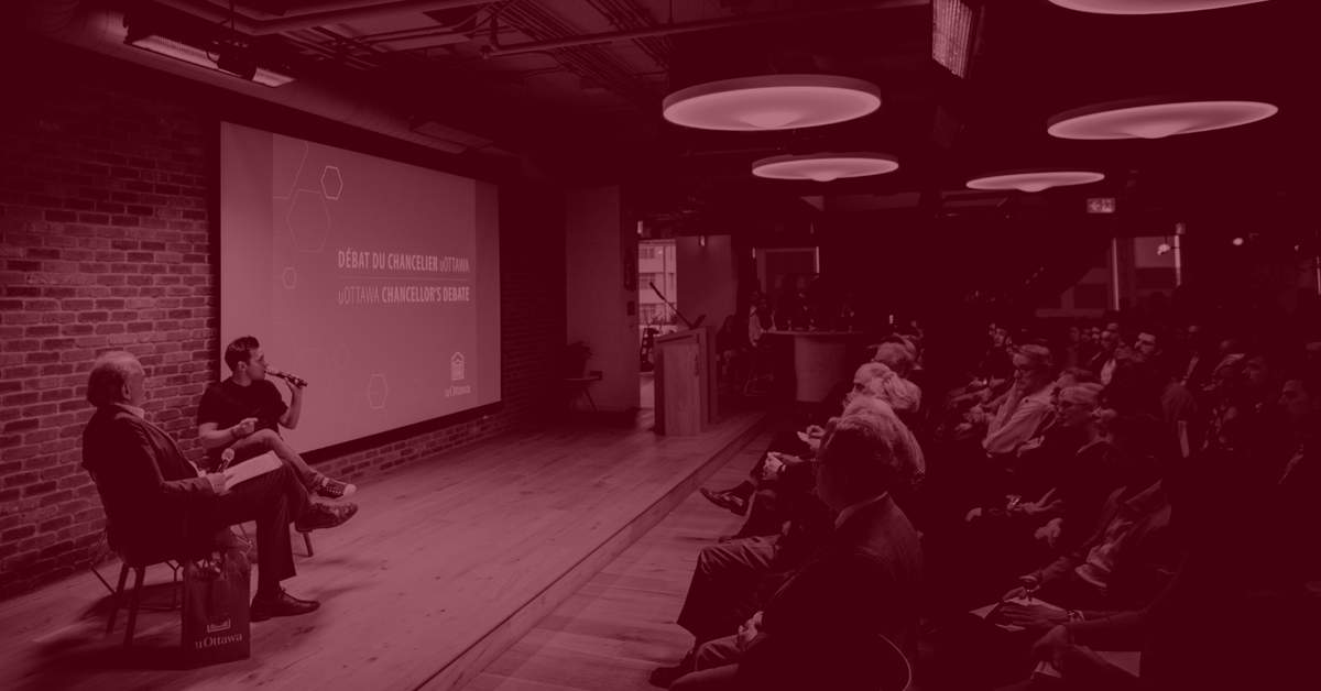 Le chancelier de l'Université d'Ottawa, Calin Rovinescu, assis sur une scène devant un auditoire.