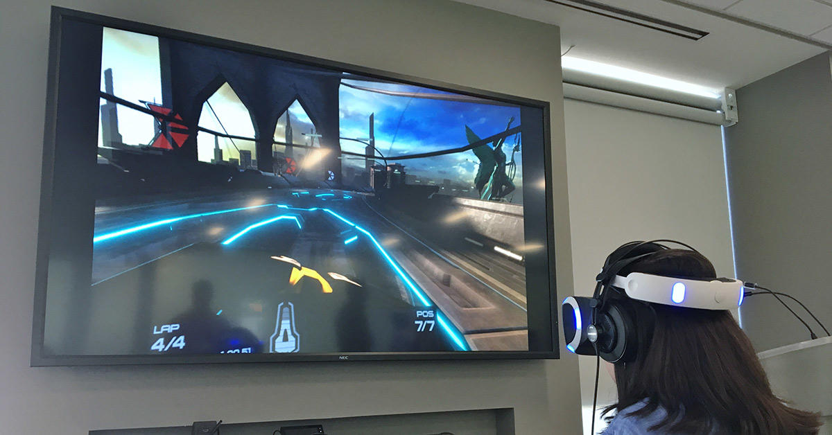 Une personne coiffée d’un casque joue à un jeu vidéo devant un téléviseur.