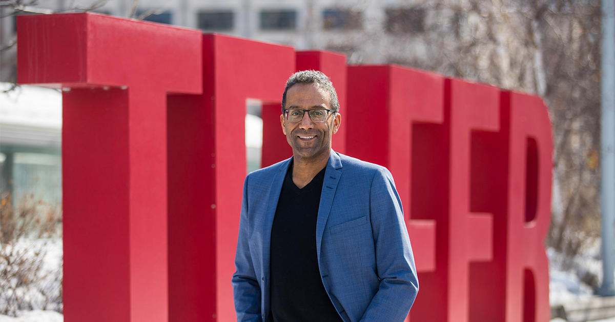 Stéphane Brutus devant les lettres géantes formant le mot TELFER