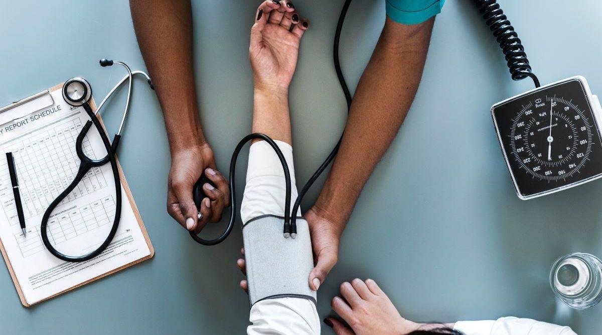 Vue aérienne d'un médecin qui mesure la pression artérielle d'une patiente.