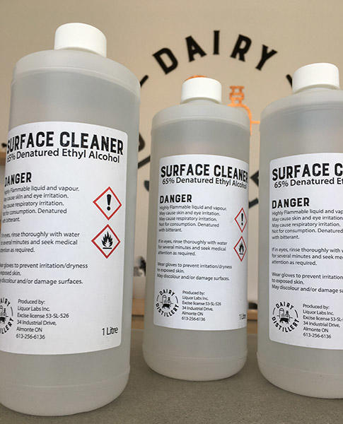trois bouteilles du désinfectant de surface créé par Dairy Distillary