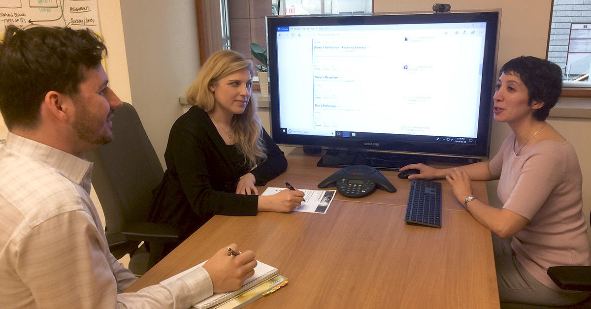 Deux conseillers en pédagogie universitaire du Centre d’innovation pédagogique et d’apprentissage numérique regardent le cours en ligne de la professeure Yasmine Abtahi sur un écran d’ordinateur dans une salle de conférences.
