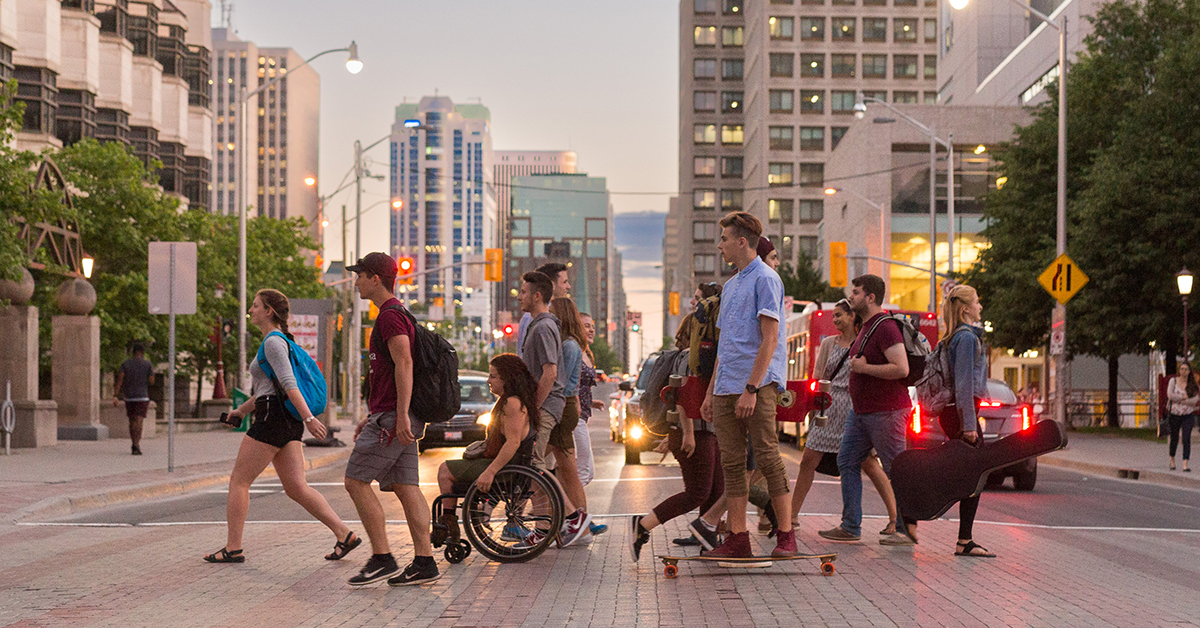 Personnes à pied ou en fauteuil roulant traversant une intersection sur le campus