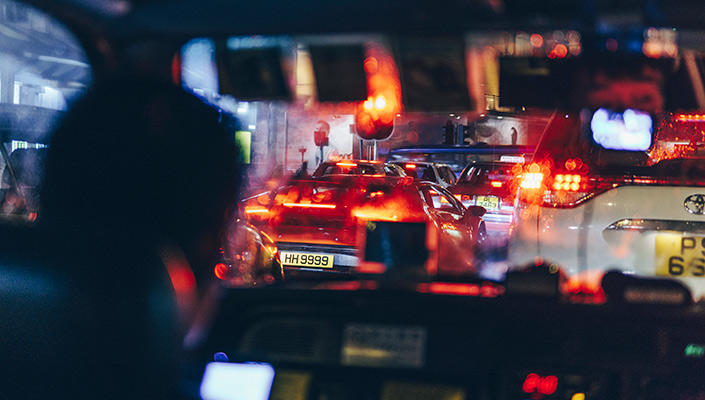 Les lumières vives de voitures vues par le pare-brise d’un taxi.