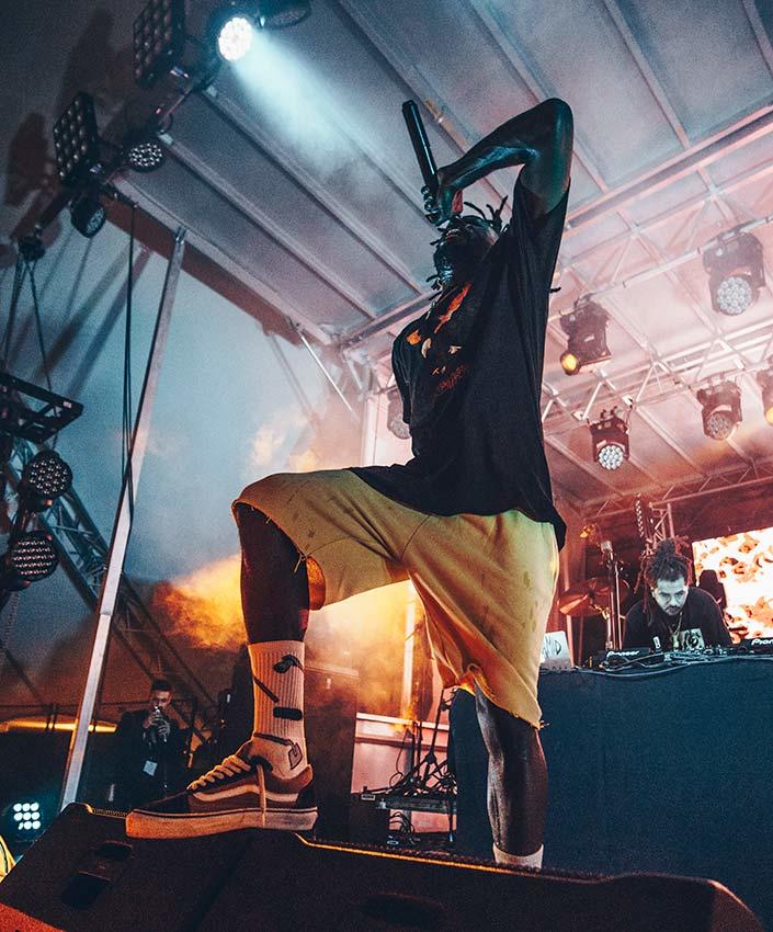 Jazz Cartier sur scène, en train de chanter dans un micro.