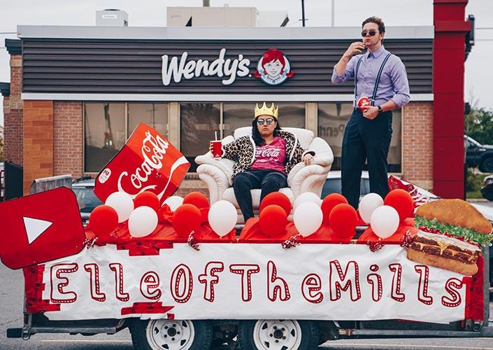Elle Mills sur un char allégorique décoré de ballons, dans le parc de stationnement d’un Wendy’s.