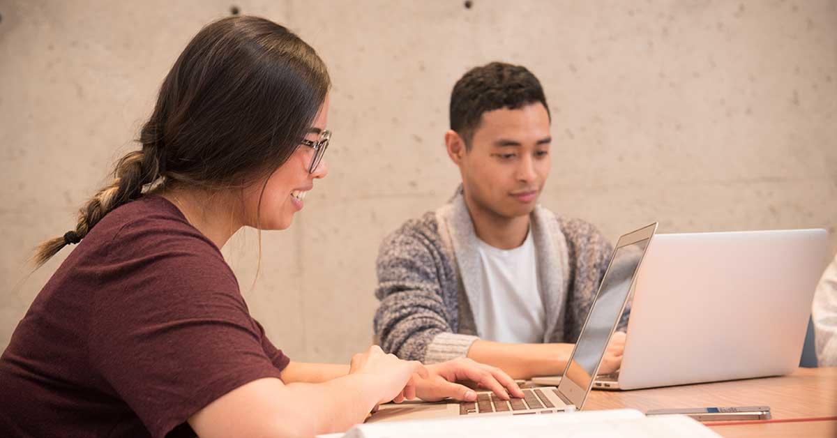 Deux étudiants travaillent sur leurs ordinateurs portables.