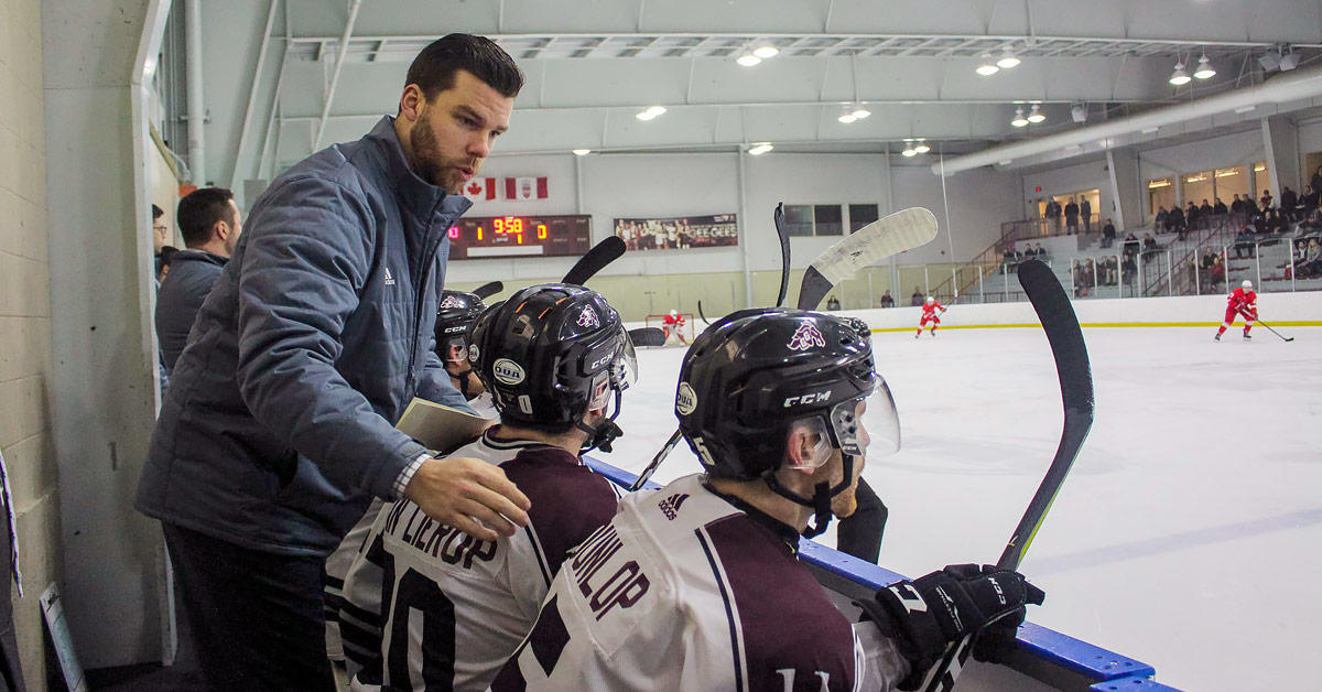 Brent Sullivan avec des joueurs sur le banc.