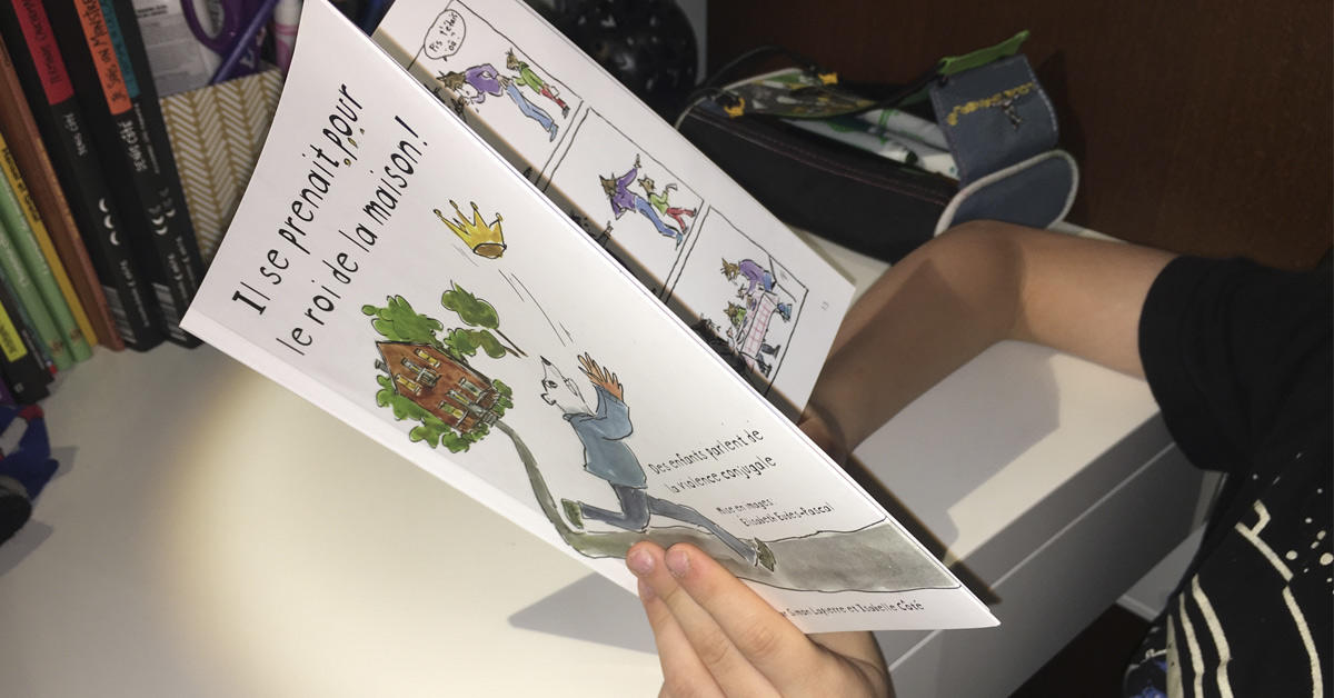 Un enfant tient le livre intitulé « Il se prenait pour le roi de la maison».