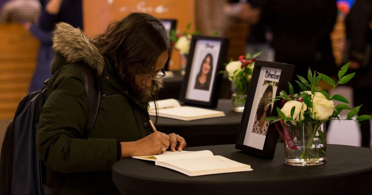A woman signs a book of condolences.